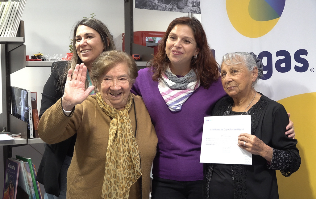 Fotografía grupal donde está presente la representante de la empresa Lipigas, la profesora del Programa de Empoderamiento Digital y a dos personas mayores, vecinas de la comuna de Renca, recibiendo su certificado por completar el curso del Programa de Empoderamiento Digital desarrollado por Conecta Mayor UC