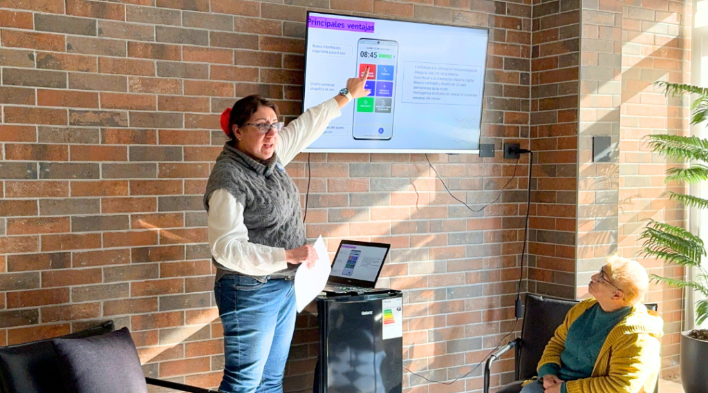 Soledad Gonzalez presentado App Mayor con una presentación proyectada en una televisión